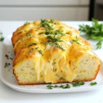 - 3 cups all-purpose flour - 1 tablespoon baking powder - 1 teaspoon salt - 1 teaspoon garlic powder - 1 teaspoon dried thyme - 1 teaspoon dried rosemary - 1 cup shredded sharp cheddar cheese - 1 1/2 cups non-alcoholic beer or club soda - 1/4 cup melted unsalted butter - 2 tablespoons fresh parsley, chopped Alternatives for Flour You can swap all-purpose flour for whole wheat flour. This change adds fiber and flavor. Cheese Options Feel free to use other cheeses like mozzarella or gouda. They will change the taste but still work well. Using Different Herbs If you lack thyme or rosemary, try oregano or basil. Each herb gives a unique twist to the bread. Preheating the Oven First, set your oven to 375°F (190°C). This heat helps the bread rise nicely. Greasing the Loaf Pan Next, take a 9x5 inch loaf pan and grease it well. Use butter or cooking spray. This step keeps the bread from sticking. Combining Dry Ingredients In a large bowl, sift together 3 cups of flour, 1 tablespoon of baking powder, and 1 teaspoon each of salt, garlic powder, dried thyme, and dried rosemary. Mix until all is well combined. Adding the Cheese Now, stir in 1 cup of shredded sharp cheddar cheese. Make sure the cheese is evenly mixed with the dry ingredients. This gives the bread its rich flavor. Pouring the Batter into the Pan Gradually pour 1 1/2 cups of non-alcoholic beer into the dry mix. Stir gently until just combined. A few lumps are fine; don’t overmix. Then, pour in 1/4 cup of melted butter and fold it in. Transfer this batter to the greased loaf pan, smoothing the top. Baking Time and Tips Bake the bread for 35-40 minutes. It’s done when the top is golden brown. Check with a toothpick; it should come out clean. After baking, let the bread cool for about 10 minutes in the pan. Then, move it to a wire rack. For a tasty touch, brush the top with more melted butter and sprinkle with fresh parsley. Avoiding Overmixing When you mix the batter, do it gently. Overmixing can make your bread dense. Stir until the dry and wet parts are just combined. A few lumps are okay. This keeps the bread light and airy. Making the Bread Fluffier To boost fluffiness, add club soda instead of beer. The bubbles in club soda help the bread rise. You can also use baking powder for extra lift. Adding Extra Herbs Feel free to add more herbs if you love flavor. Fresh chives or basil can brighten the taste. Just chop the herbs finely and fold them in with the cheese. Incorporating Spices Want a kick? Try adding a pinch of cayenne pepper or smoked paprika. These spices add warmth and depth to your bread. Experiment with what you enjoy! Best Pairings This bread pairs well with soups and stews. Serve it with a bowl of chili or a fresh salad. The cheesy flavor complements many dishes. Grinding Cheese Topping For a gourmet touch, sprinkle more cheese on top before baking. You can also grind some cheese over the warm bread after it cools. It adds a nice finish and extra flavor. {{image_2}} You can change the taste of your beer bread by adding new flavors. Here are two fun ideas: - Spicy Cheddar and Jalapeño: Add sliced jalapeños and use pepper jack cheese. This makes the bread spicy and creamy. The heat from the jalapeños pairs well with the sharp cheese. - Herb and Olive Oil Bread: Skip the cheese and mix in olive oil for a lighter flavor. Use fresh herbs like basil and oregano. This gives a fragrant touch that’s perfect for dipping in olive oil or balsamic vinegar. If you need a gluten-free bread, you can still enjoy this recipe. Here’s how: - Using Gluten-Free Flour: Swap the all-purpose flour with a gluten-free blend. Make sure the blend has a good structure. This helps the bread rise nicely. - Adjusting Baking Time: Gluten-free bread may need a bit more time in the oven. Check it with a toothpick to see if it is done. If it’s still wet, bake for another 5 minutes. You can make your beer bread fit the season too. Here are two tasty ideas: - Fall Pumpkin Beer Bread: Add one cup of pumpkin puree and a bit of cinnamon. This makes a warm, cozy flavor perfect for autumn. - Summer Herb and Lemon Bread: Mix in fresh lemon zest and herbs like dill or mint. This gives a refreshing taste that’s great for summer meals. To keep your savory cheddar and herb beer bread fresh, store it correctly. - Room Temperature Storage: Place the bread in a breadbox or a paper bag. This keeps the crust crisp. It stays fresh for about 2-3 days. Avoid plastic bags; they make the bread soggy. - Refrigeration Tips: If you need to keep it longer, wrap it in plastic wrap. Then place it in an airtight container. This method helps it last about a week. But refrigeration can dry out the bread. Freezing is a great way to save any leftovers. - Proper Freezing Methods: First, let the bread cool completely. Wrap it tightly in plastic wrap. Then, place it in a freezer bag or container. Label it with the date. This keeps it fresh for up to 3 months. - Thawing Instructions: To enjoy your bread again, thaw it in the fridge overnight. If you're short on time, leave it at room temperature for 1-2 hours. You can warm it up in the oven for a few minutes before serving. This brings back the fresh taste and texture. This bread stays fresh for about 2 to 3 days at room temperature. To keep it fresh, wrap it in plastic wrap or foil. If you want to keep it longer, you can freeze it. It will stay good for about 3 months in the freezer. Just make sure to slice it first for easy thawing. Yes, you can use regular beer in this recipe. The beer adds great flavor and makes the bread rise. If you prefer a lighter taste, club soda works well too. Just keep in mind that the flavor will change slightly with different types of beer. Cheese bread pairs well with many dishes. You can serve it with soups or stews. It’s also great with herbed butter or olive oil for dipping. Try it with a fresh salad or as a side to grilled meats. The options are endless! To make this recipe vegan, you can replace the melted butter with a plant-based butter. Use a vegan cheese for the cheddar. Instead of non-alcoholic beer, you can use club soda or plant-based milk. This way, you can enjoy the same great taste without animal products. Yes, you can use a different size pan. If you use a smaller pan, the bread will need more time to bake. For a larger pan, it may bake faster. Always check for doneness with a toothpick to make sure it’s fully cooked in the center. This bread recipe combines simple ingredients for tasty results. You learned how to mix, bake, and add flavor to your bread. Remember to use my tips for texture and variations to keep it exciting. Whether you prefer spicy or herb flavors, there is an option for everyone. Store leftovers properly to enjoy later. I hope you feel inspired to bake and share this delightful bread with others. Happy baking!