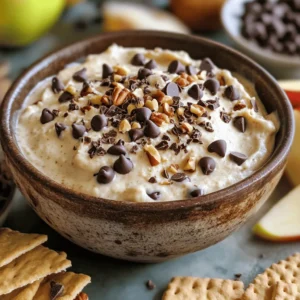 - 1 cup all-purpose flour (heat-treated) - 1/2 cup cream cheese, softened - 1/4 cup unsalted butter, softened - 1/2 cup brown sugar, packed - 1/4 cup granulated sugar - 1 teaspoon vanilla extract - 1/4 teaspoon salt - 1/2 cup mini chocolate chips - Optional: 1/4 cup chopped nuts (pecans or walnuts) For this Chocolate Chip Cookie Dough Dip, I choose each ingredient carefully. The flour is vital and must be heat-treated. This step makes it safe to eat. I bake the flour for five minutes at 350°F. It helps kill any bacteria. After baking, let it cool. Next, the cream cheese and butter create a creamy base. I always use softened versions for best mixing. This makes the dip smooth and rich. The brown sugar gives that deep, sweet flavor. The granulated sugar adds a nice touch of sweetness. I add vanilla extract for a warm flavor. It makes every bite feel special. A pinch of salt balances all the sweetness. Then come the mini chocolate chips. They add texture and bursts of chocolate joy. If you want a crunch, add chopped nuts. Pecans or walnuts work well here. They give a nice contrast to the smooth dip. Each ingredient plays a role in making this dip delicious and fun. First, we need to heat-treat the flour. This step kills any bacteria. Spread 1 cup of all-purpose flour on a baking sheet. Bake it in a preheated oven at 350°F (175°C) for 5 minutes. Let it cool completely before using. This makes your dip safe to eat. Next, we mix the base. In a medium bowl, take 1/2 cup of softened cream cheese and 1/4 cup of softened butter. Using an electric mixer, beat them together. Do this for about 1-2 minutes. You want a smooth and creamy mix. Now, it’s time to add sweetness. Slowly mix in 1/2 cup of brown sugar and 1/4 cup of granulated sugar. Make sure to scrape down the bowl as you mix. This ensures all the sugar blends in well. Then, we’ll flavor the dip. Add the cooled flour, 1 teaspoon of vanilla extract, and 1/4 teaspoon of salt to the bowl. Mix on low speed until everything is combined. This step is key for a tasty dip. Lastly, fold in the chocolate chips. Use 1/2 cup of mini chocolate chips for that classic flavor. If you want, add 1/4 cup of chopped nuts for crunch. This is optional, but it adds texture. For enhanced flavor, you can chill the dip for about 30 minutes before serving. Enjoy it with graham crackers, pretzels, or apple slices. - Not heat-treating the flour: This step is very important. Raw flour can have germs that cause illness. To keep it safe, heat-treat your flour first. Spread it on a baking sheet and bake it at 350°F for 5 minutes. Let it cool before using. - Overmixing ingredients: Mixing too much can make your dip tough. Once you combine the flour, sugar, and cream cheese, stop mixing when everything is just blended. This keeps the dip creamy and smooth. - Achieving the creamy consistency: To get that perfect creamy dip, beat the cream cheese and butter until smooth. Use an electric mixer for 1-2 minutes. This makes sure there are no lumps. - Tips for folding ingredients: When adding chocolate chips, fold them in gently. Use a spatula to ensure even distribution. This keeps the chips from breaking and makes every bite delightful. - Suggestions for ingredient variations: You can add fun flavors! Try different chips, like dark or white chocolate. For a twist, consider adding a pinch of cinnamon or even some peanut butter. - How to balance sweetness: If you find the dip too sweet, add a bit more salt. This can help balance out the flavors. You can also use less sugar if you prefer a less sweet dip. Adjust to your taste! {{image_2}} You can change the taste of your dip by adding different chocolate types. Use dark chocolate chips for a richer flavor. If you like a sweeter taste, try white chocolate chips. You can also add seasonal flavors. For fall, mix in pumpkin spice. During winter, add peppermint extract for a festive twist. If you want a lighter dip, use light cream cheese or Greek yogurt instead of regular cream cheese. This gives you a creamy dip with fewer calories. For sweetness, try sugar alternatives like stevia or monk fruit. These options keep the dip tasty but lower in sugar. The right dippers make your dip even better. Try fresh fruits like apple slices or strawberries. Graham crackers and pretzels also work well. For themed parties, serve the dip in a fun bowl and add decorations. Use holiday colors or shapes to make it festive. To keep your chocolate chip cookie dough dip fresh, store it in the refrigerator. Use an airtight container for the best results. This helps keep the dip moist and tasty. Make sure to seal the container tightly before putting it away. You can enjoy it for several days, but it tastes best fresh. Yes, you can freeze this dip! Just scoop it into a freezer-safe container. Make sure to leave some space at the top, as it will expand when frozen. To thaw, move it to the fridge for a few hours or overnight. Stir it well before serving. This helps bring back its creamy texture. In the fridge, your dip lasts about 5 to 7 days. Keep an eye out for signs that it has gone bad. If it smells off or shows mold, it’s time to toss it. Freshness is key to enjoying this delicious treat! No, you should not eat raw flour. Raw flour can carry harmful bacteria. To make it safe, heat-treat the flour. Spread it on a baking sheet and bake at 350°F for five minutes. This kills any bacteria. Let it cool before using in the dip. This dip is quick and easy to make. It takes about 15 minutes to prep. The total time, including baking the flour, is around 45 minutes. This gives you time to enjoy your tasty treat soon. You can serve this dip with many tasty dippables. Some great options are: - Graham crackers - Pretzels - Apple slices - Vanilla wafers Feel free to mix and match your favorites! Yes, you can make this dip vegan! Here are some easy swaps: - Use plant-based cream cheese instead of regular cream cheese. - Replace butter with coconut oil or vegan butter. - Choose a vegan sugar option if needed. These changes keep the dip creamy and delicious! This blog post guided you through the tasty world of Chocolate Chip Cookie Dough Dip. We covered each important ingredient, gave step-by-step instructions, and shared tips to avoid mistakes. I also shared fun variations and storage ideas to keep your dip fresh. You can enjoy this sweet treat safely and creatively. Remember, with these easy steps, you can impress anyone with your dip. Get ready to dip into flavor!