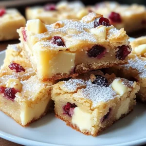 To make these delicious White Chocolate Cranberry Blondies, gather the following ingredients: - 1 cup (2 sticks) unsalted butter, melted - 1 1/2 cups packed brown sugar - 2 large eggs - 2 teaspoons vanilla extract - 2 cups all-purpose flour - 1/2 teaspoon baking powder - 1/4 teaspoon salt - 1 cup white chocolate chips - 1 cup dried cranberries - Zest of 1 orange (optional for extra flavor) Each ingredient plays a key role in creating the perfect blondie. The unsalted butter gives richness and moisture. Brown sugar adds sweetness and a chewy texture. Eggs help bind everything together. Vanilla extract adds warmth and depth. All-purpose flour forms the base of the batter. Baking powder helps the blondies rise, while salt enhances the flavors. White chocolate chips provide creamy sweetness, and dried cranberries add a tart burst. If you want a hint of citrus, the orange zest is a lovely touch. These simple yet flavorful ingredients combine to create a delightful treat. Each bite offers a mix of creamy, sweet, and tart flavors. {{ingredient_image_1}} - Grease a 9x13 inch baking pan or line it with parchment paper. - Preheat your oven to 350°F (175°C). This step is key for even baking. - In a large bowl, add 1 cup of melted unsalted butter and 1 1/2 cups of packed brown sugar. Mix until smooth. - Next, add 2 large eggs one at a time. Mix well after each addition. Stir in 2 teaspoons of vanilla extract until it blends fully. - In another bowl, whisk together 2 cups of all-purpose flour, 1/2 teaspoon of baking powder, and 1/4 teaspoon of salt. This mix helps with the rise. - Gradually add the dry mix to the wet mix. Stir gently until just combined. - Fold in 1 cup of white chocolate chips, 1 cup of dried cranberries, and the zest of 1 orange if you want extra flavor. - Pour the batter into your prepared pan. Spread it evenly with a spatula. - Bake for 25-30 minutes. Check for doneness by inserting a toothpick in the center. It should come out mostly clean with a few crumbs. - Let the blondies cool in the pan for at least 15 minutes. - After cooling, slice into squares. Serve warm or at room temperature. For a treat, add a dusting of powdered sugar or a scoop of vanilla ice cream. To make these blondies shine, you can swap some ingredients. For example, use coconut oil instead of butter for a fun twist. You can also try brown sugar with granulated sugar for a lighter taste. Just keep the ratios the same. Texture is key for great blondies. You want them soft and chewy, not dry. Make sure you don’t overmix your batter. When you add the flour, mix until just combined. This keeps the blondies soft and moist. Warm blondies are amazing. They melt in your mouth! You can serve them at room temperature, too. If you want to elevate your dessert, add a scoop of vanilla ice cream or a dollop of whipped cream. The cold cream pairs well with the warm blondies. To store your blondies, place them in an airtight container. They stay fresh for about a week at room temperature. If you need them to last longer, freeze them! Wrap each blondie in plastic wrap and place them in a freezer bag. They freeze well for up to three months. When you want one, just thaw it at room temperature. Pro Tips Use Room Temperature Eggs: Using eggs that are at room temperature helps them incorporate better into the batter, resulting in a smoother texture. Don’t Overmix the Batter: Mix the batter just until the dry ingredients are incorporated to maintain a soft and chewy texture. Check for Doneness: Insert a toothpick into the center; it should come out with a few moist crumbs for perfectly baked blondies. Enhance Flavor with Spices: Add a pinch of cinnamon or nutmeg for a warm, spiced flavor that complements the white chocolate and cranberries. {{image_2}} You can play with flavors in your blondies. Try using different types of chocolate. Swap white chocolate chips for dark or milk chocolate. Each type will change the taste a bit. You can also add nuts like walnuts or pecans. These give a nice crunch. Other dried fruits, like cherries or apricots, work well too. They add sweetness and color. Want gluten-free blondies? You can make them easily. Use a gluten-free flour blend instead of all-purpose flour. Look for blends that have xanthan gum, which helps with texture. Almond flour is another great choice. It gives a nutty flavor and moistness. Just replace all-purpose flour with the same amount of almond flour. If you need vegan options, replace the eggs with flaxseed meal. Mix 1 tablespoon of flaxseed with 3 tablespoons of water. Let it sit until it gets thick. Substitute the butter with coconut oil or vegan butter. For sugar-free blondies, use a sweetener like monk fruit or stevia. Adjust the amount to taste. These swaps keep your blondies tasty and guilt-free. Blondies are a sweet treat similar to brownies. They have a rich, buttery flavor and a chewy texture. Unlike brownies, blondies do not use cocoa powder. Instead, they rely on brown sugar for sweetness and a hint of caramel flavor. Differences between blondies and brownies: - Color: Blondies are light while brownies are dark. - Flavor: Blondies taste sweet and buttery; brownies taste chocolatey. - Ingredients: Blondies use brown sugar; brownies use cocoa powder. Yes, you can freeze these blondies easily. How to properly freeze and thaw them: 1. Allow the blondies to cool completely. 2. Cut them into squares. 3. Wrap each square tightly in plastic wrap. 4. Place the wrapped squares in a freezer bag. 5. To thaw, leave them in the fridge overnight or at room temperature for a few hours. Dry blondies can happen for a few reasons. Common mistakes and how to avoid them: - Overbaking: Keep an eye on the time. Bake until edges are golden. - Too much flour: Measure flour carefully. Use a spoon to scoop, then level it off. - Not enough fat: The butter gives moisture. Ensure you use the right amount. You can use fresh cranberries, but they change the texture. Effects on texture and sweetness: - Fresh cranberries add moisture, making blondies softer. - They are tart and may need extra sugar to balance the taste. - Dried cranberries provide sweetness and chewiness, which enhances the blondies. Each blondie serves as a delightful treat. One piece has about 180 calories. It contains 8 grams of fat. The carbs come in at around 26 grams. These numbers may vary based on the size of your pieces. The ingredients in these blondies bring some good nutrients: - Butter: It adds rich flavor and some vitamins. - Brown Sugar: It provides energy and a deeper taste. - Eggs: They offer protein and healthy fats. - Flour: It is a source of carbs for energy. - White Chocolate Chips: They add sweetness but are high in sugar. - Dried Cranberries: They give fiber and antioxidants. - Orange Zest: It brings vitamin C and brightens flavor. Allergen Information: This recipe contains common allergens like gluten, dairy, and eggs. Those with nut allergies can enjoy this recipe, as it does not include nuts. Always check ingredient labels for cross-contamination warnings. You've learned how to make delicious White Chocolate Cranberry Blondies with simple steps. We covered all the key ingredients and how to prepare them. I shared tips for perfecting your blondies and more ways to enjoy them. Remember, you can even try variations to suit your taste. These treats are easy, fun, and satisfying. I hope you feel excited to bake and share these tasty bars! Enjoy your delicious creation!