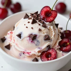 To make Cherry Chocolate Chip Ice Cream, you need these key items: - 2 cups fresh cherries, pitted and halved - 1 cup heavy cream - 1 cup whole milk - 3/4 cup granulated sugar - 1 teaspoon vanilla extract - 1/4 teaspoon almond extract - 1 cup semi-sweet chocolate chips - A pinch of salt These ingredients give the ice cream its rich taste and creamy texture. Fresh cherries add a sweet and tart flavor. The chocolate chips provide a nice contrast. You can add these items for extra flavor: - A splash of lemon juice for brightness - Chopped nuts like almonds or walnuts for crunch - Swirls of chocolate syrup for a rich finish These enhancements make the ice cream even more fun to eat. You can mix and match based on your taste. If you have dietary needs, try these substitutions: - Use coconut milk instead of whole milk for a dairy-free option. - Substitute maple syrup for granulated sugar for a natural sweetener. - Use dark chocolate chips if you prefer a richer chocolate flavor. These swaps help you enjoy the ice cream while meeting your dietary needs. {{ingredient_image_1}} Start by pitting and halving 2 cups of fresh cherries. Place the cherries in a medium saucepan. Add 1/4 cup of granulated sugar. Cook over medium heat for about 5 minutes. Stir gently as the cherries cook. You want them soft and juicy. Once done, take them off the heat and let them cool. This step makes the cherries sweet and tasty. In a large bowl, combine 1 cup of heavy cream and 1 cup of whole milk. Add the remaining 1/2 cup of sugar, 1 teaspoon of vanilla extract, and 1/4 teaspoon of almond extract. Sprinkle in a pinch of salt. Use a whisk to mix everything well until the sugar is fully dissolved. This mixture creates a rich and creamy base for your ice cream. Once your cherry mixture has cooled, gently fold it into the cream base. Be careful not to break up the cherries too much. Next, stir in 1 cup of semi-sweet chocolate chips. This adds a sweet crunch. Pour the mixture into your ice cream maker. Churn according to the manufacturer's instructions, usually for 20 to 25 minutes. After churning, transfer the ice cream to an airtight container. Freeze for at least 4 hours until it is firm. When ready to serve, let it sit out for 10 minutes for easy scooping. Enjoy! To get smooth ice cream, start with cold ingredients. Chill the heavy cream and milk before mixing. This helps the ice cream churn better. When you mix, fold the cherry mixture gently into the cream. This keeps the cherries whole and adds texture. Churning is key too! Follow your ice cream maker's time. Over-churning can make ice cream too hard. Aim for a soft-serve texture before freezing. Finally, let it freeze in an airtight container to set. This will give you a perfect scoop. I love serving this cherry chocolate chip ice cream in waffle cones. The crunch of the cone complements the creamy ice cream. You can also use bowls. Add fresh cherry halves on top for a pop of color. A sprinkle of chocolate shavings makes it look fancy. Try pairing it with a slice of warm chocolate cake. The hot cake with cold ice cream is a treat! You can also serve it with fresh fruit, like strawberries or raspberries. The flavors blend nicely and create a fun dessert. To keep your ice cream fresh, store it in an airtight container. This prevents ice crystals from forming. If you have space, keep it in the back of the freezer. The front can get too warm when the door opens. Label your container with the date. Homemade ice cream lasts about two weeks in the freezer. If it gets too hard, let it sit out for ten minutes before scooping. This makes it easier to serve! Pro Tips Fresh Cherries Are Best: For the most vibrant flavor, use fresh, ripe cherries when making this ice cream. Frozen cherries can work, but they may lead to a softer texture. Chill Your Mixture: Before churning, chill the ice cream mixture in the refrigerator for at least an hour. This helps to speed up the churning process and results in a creamier texture. Experiment with Extracts: Feel free to adjust the almond extract or add other flavors like mint or coconut to create your own twist on this delightful ice cream. Storage Tips: To maintain the best texture, store your ice cream in a shallow airtight container. This minimizes ice crystal formation, keeping your ice cream smooth and creamy. {{image_2}} You can switch up the flavors in your Cherry Chocolate Chip Ice Cream. Try using raspberries instead of cherries. Their bright taste pairs well with chocolate. You can also mix in some mint. Mint adds a cool twist that tastes great in summer. For a nutty flavor, add crushed pistachios or almonds. These nuts add both crunch and taste. If you want a dairy-free version, use coconut milk instead of cream and milk. Coconut milk gives it a creamy texture. Use maple syrup or agave for sweetening. These options keep it vegan while adding a unique flavor. You can also try almond milk for a lighter option. Just remember to check for dairy-free chocolate chips. Adding different mix-ins can make your ice cream even better. Chopped nuts, like walnuts or pecans, add crunch. You can also add crushed cookies for a fun twist. Try Oreos or graham crackers for extra flavor. For a fruity burst, mix in some diced strawberries or blueberries. These add color and sweetness to each scoop. This Cherry Chocolate Chip Ice Cream is a treat, and it does have calories. A serving contains about 250-300 calories. The main sources are the heavy cream and sugar. Each scoop brings creamy joy and a few extra calories. Fresh cherries offer many health perks. They are rich in vitamins and antioxidants. Cherries can help reduce inflammation and improve sleep. The heavy cream adds calcium, while chocolate chips provide a quick energy boost. Almond extract gives a nice flavor and may aid digestion. Homemade ice cream is often healthier than store-bought. Many store brands use artificial flavors and preservatives. You control the ingredients in your kitchen. You also avoid excess sugar and fat. Making ice cream at home lets you enjoy real flavor without the guilt. Yes, you can make this ice cream without a machine. Use a large bowl to mix the ingredients. Pour the mixture into a shallow dish. Place it in the freezer. Stir it every 30 minutes for about 3 hours. This helps break up ice crystals. You&rsquo;ll get a nice, creamy texture. Homemade ice cream can last about 2 to 3 weeks in the freezer. Keep it in an airtight container. This helps prevent ice crystals from forming. Always check for any off smells or changes in texture before serving. If it looks good, it&rsquo;s likely safe to eat. If the ice cream is too hard, let it sit at room temperature. Wait for about 10 minutes. This softens it up a bit. You can also use a warm scoop to dig in. Just run the scoop under warm water for a few seconds. This makes serving much easier. You can create delicious cherry chocolate chip ice cream at home with simple steps. Start with essential ingredients, add flavor enhancements, and know your dietary options. Follow the steps for mixing and churning, and use tips for best results. Experiment with variations for unique flavors and textures. Remember, your homemade ice cream is not just tasty; it&rsquo;s often healthier than store-bought versions. Enjoy your ice cream journey, and let your creativity flow!